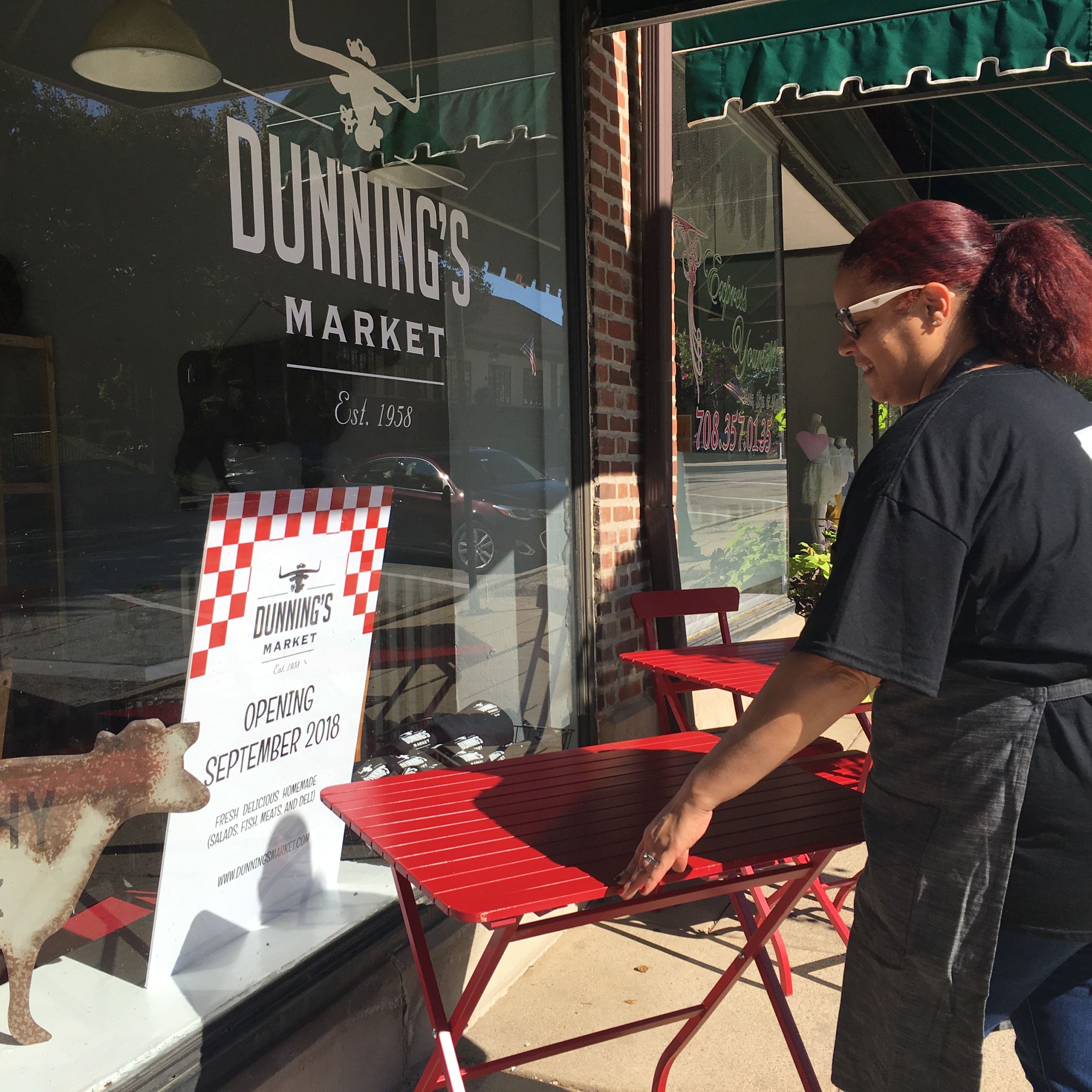 Woman Setting Up Tables Outside Dunning's Market